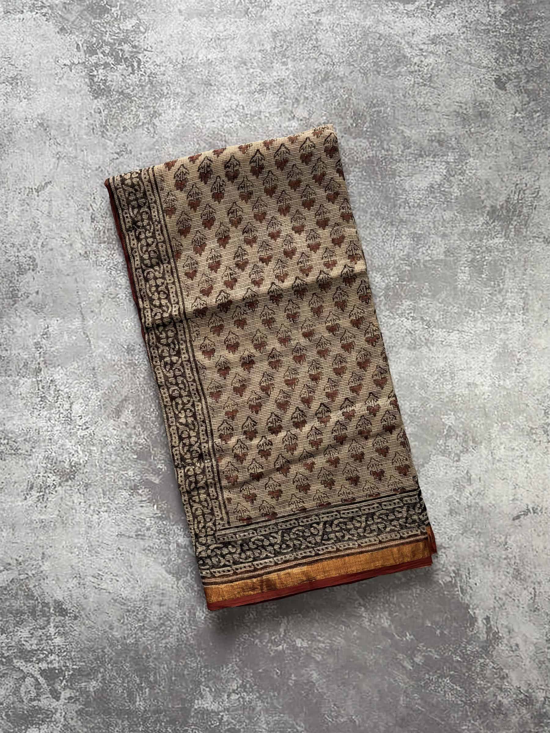 Beige hand block printed Kota Doria saree with rust floral motifs and traditional pallu