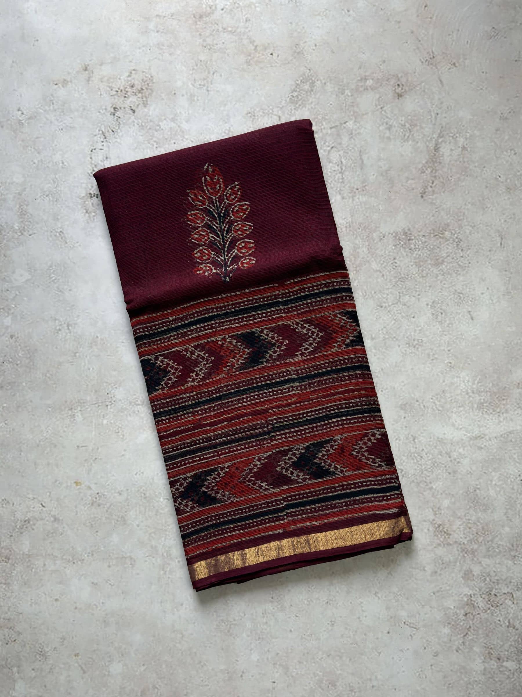 Maroon hand block printed Kota Doria saree with Ikat inspired border and pallu